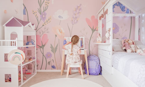 Image of a girl with a wall of custom wallpaper in the background.